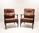 A pair of easy chairs of polished wood and dark brown leather, danish design from the 1960s.5000m2 showroom.